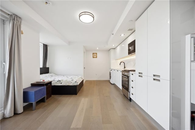 623 H Ave Unit 7C, New York, NY 11230 - bedroom featuring light wood-type flooring, washer / dryer, recessed lighting, baseboards, and a sink