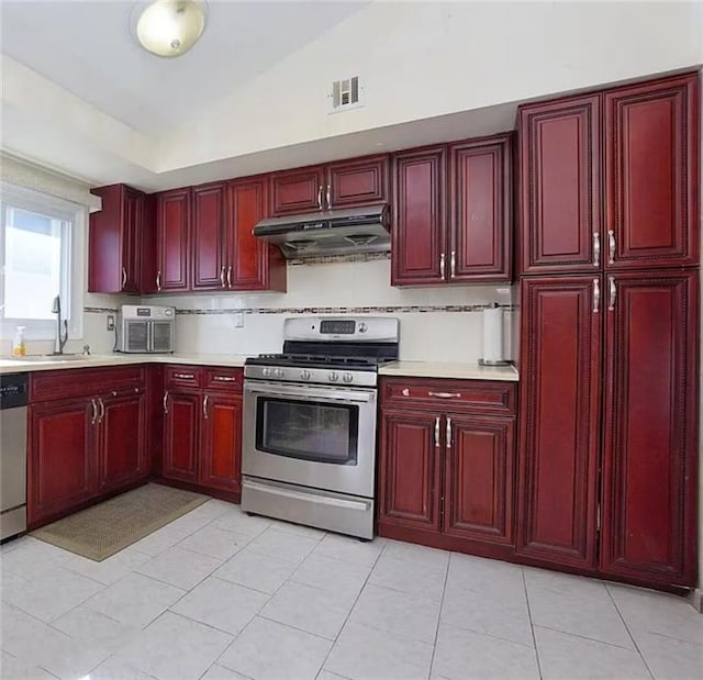 32 Dickie Ave, Staten Island, NY 10314 - kitchen featuring stainless steel appliances, under cabinet range hood, reddish brown cabinets, and a sink