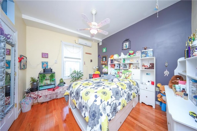 bedroom featuring ceiling fan, light wood-type flooring, and a wall mounted air conditioner