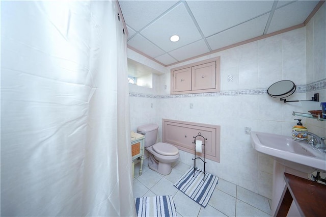 bathroom featuring toilet, tile patterned flooring, and tile walls