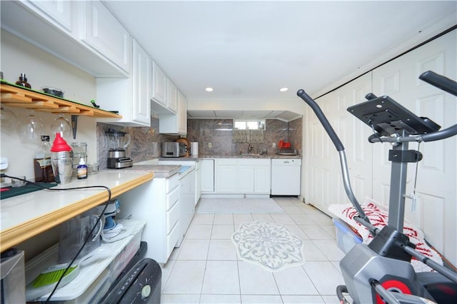 kitchen with white dishwasher, white cabinetry, decorative backsplash, and light countertops
