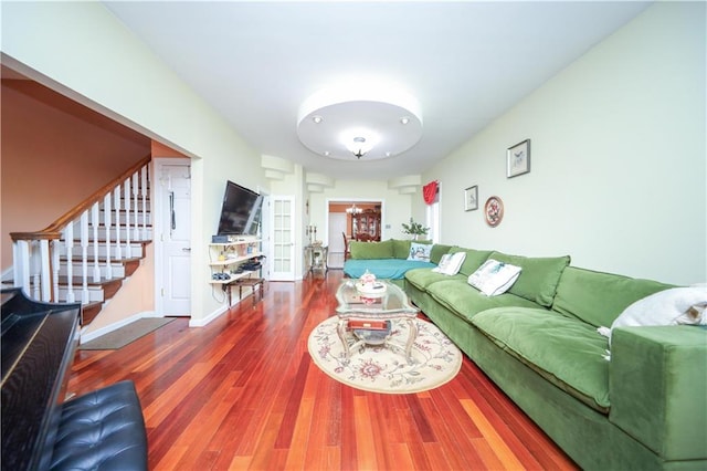 living area with stairway, wood finished floors, and baseboards