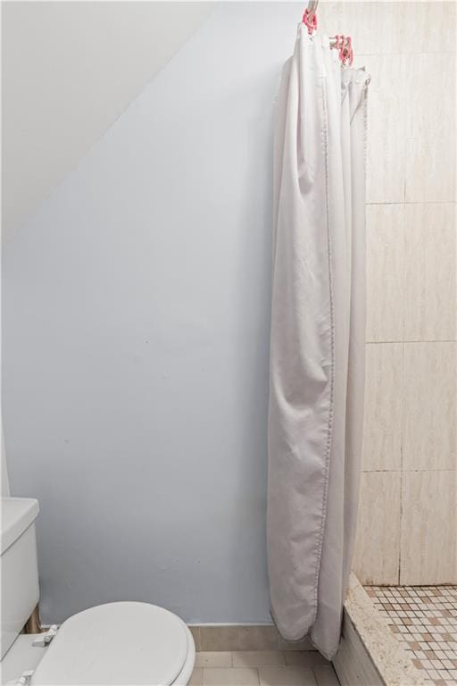 full bathroom with toilet, a stall shower, and tile patterned floors