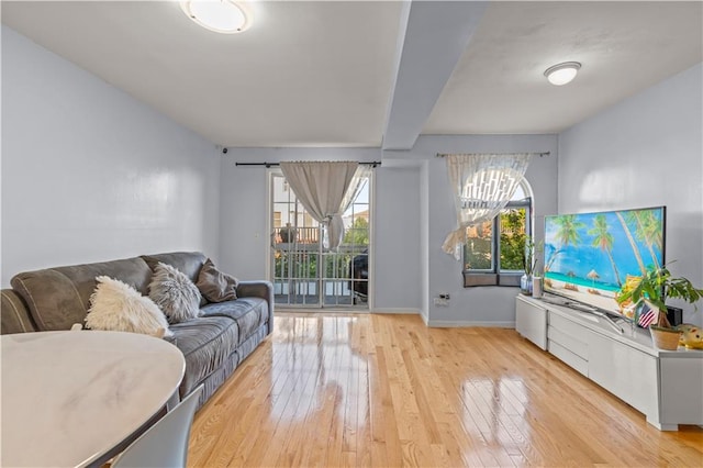 living room featuring a healthy amount of sunlight, baseboards, and light wood-style floors