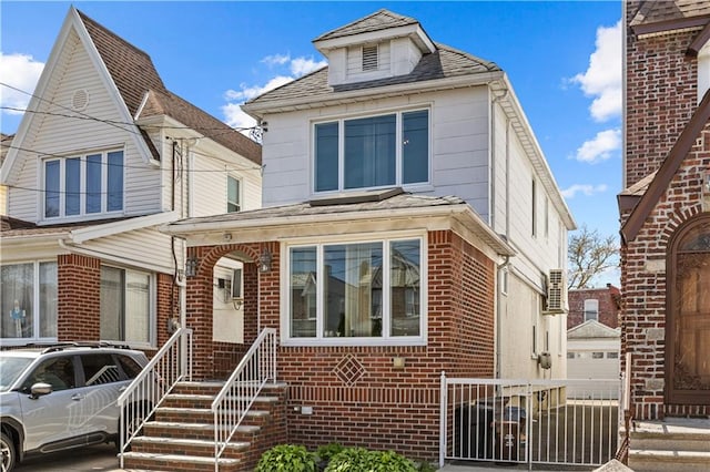 american foursquare style home featuring brick siding and fence