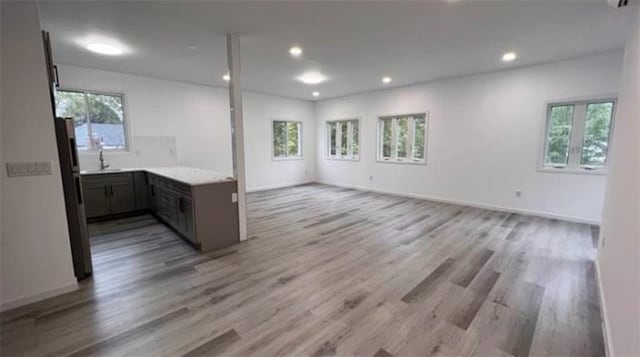 unfurnished living room featuring plenty of natural light, light wood-type flooring, and recessed lighting