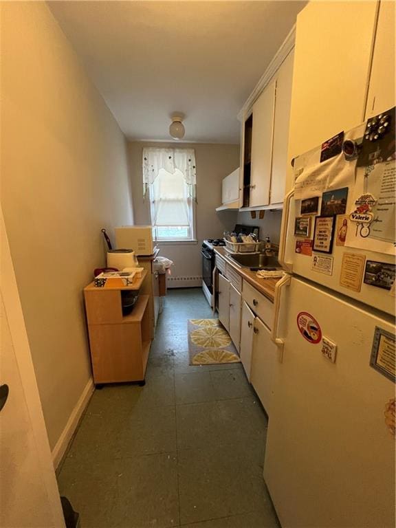 1774 E 54th St Unit 13B, Brooklyn, NY 11234 - kitchen with freestanding refrigerator, range with gas stovetop, white cabinets, a sink, and baseboards