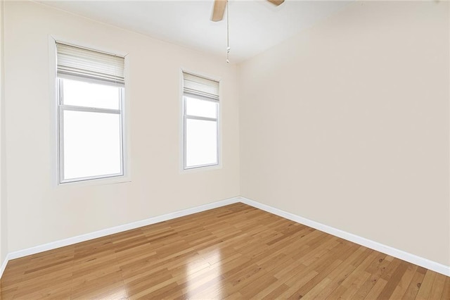 empty room with baseboards, ceiling fan, and light wood finished floors