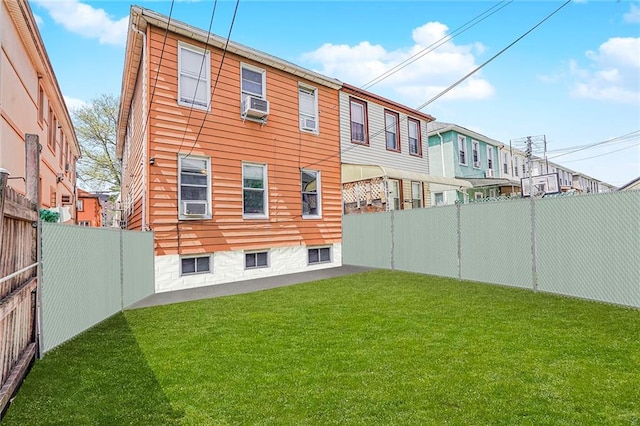 back of house with a yard, cooling unit, and a fenced backyard