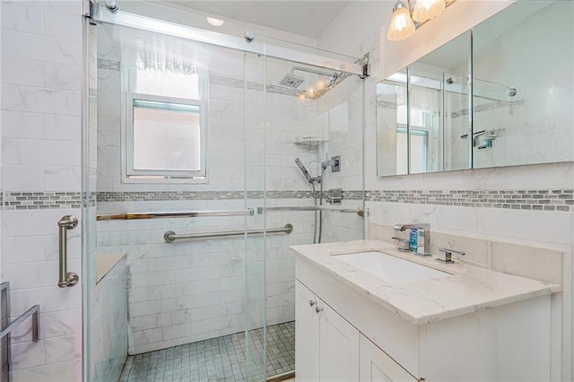 full bath featuring vanity, a shower stall, and tile walls