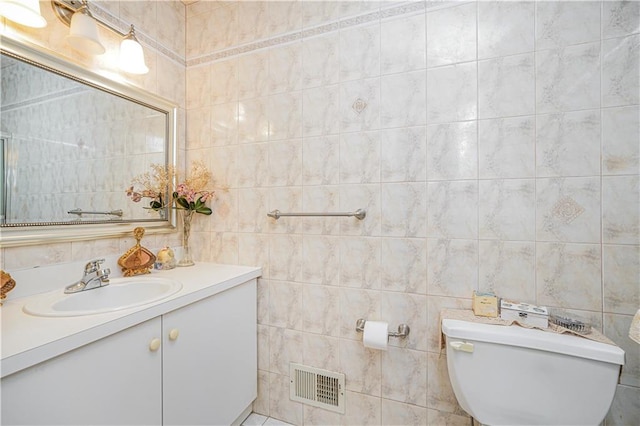 bathroom with tile walls, toilet, visible vents, and vanity