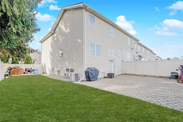 back of property featuring a yard, a patio, and a fenced backyard