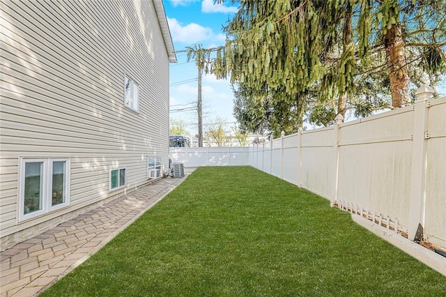 view of yard featuring central air condition unit and a fenced backyard