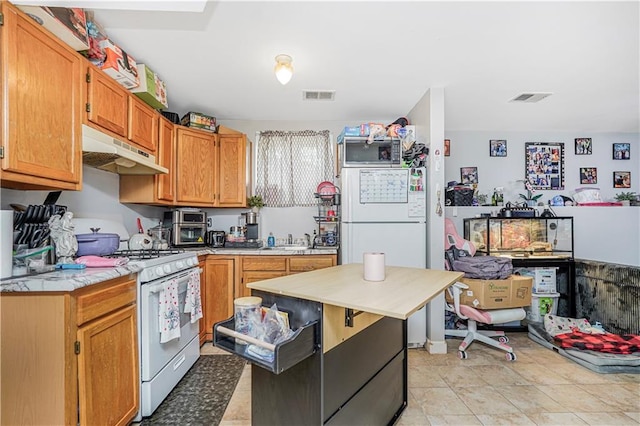 kitchen with visible vents, white gas range oven, under cabinet range hood, and light countertops