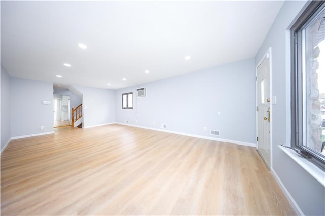 unfurnished living room with stairs, light wood-style floors, recessed lighting, and baseboards
