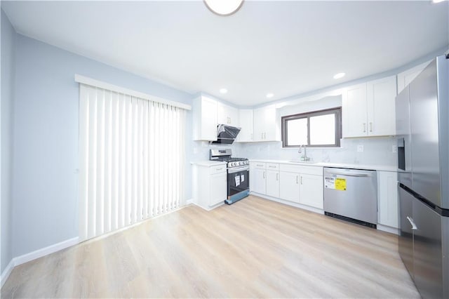 kitchen featuring stainless steel appliances, a sink, light countertops, light wood-style flooring, and recessed lighting
