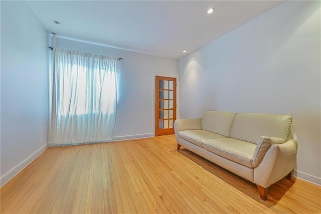 living area with baseboards, recessed lighting, and hardwood / wood-style floors