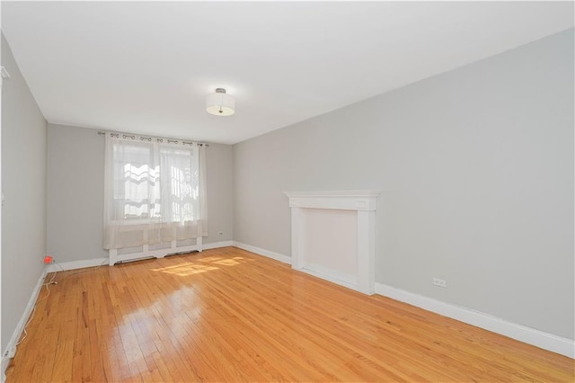 unfurnished room featuring baseboards and light wood-style flooring