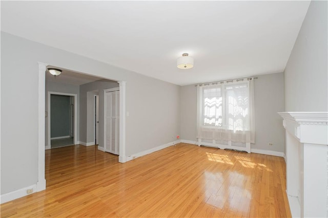 unfurnished living room with baseboards and light wood finished floors