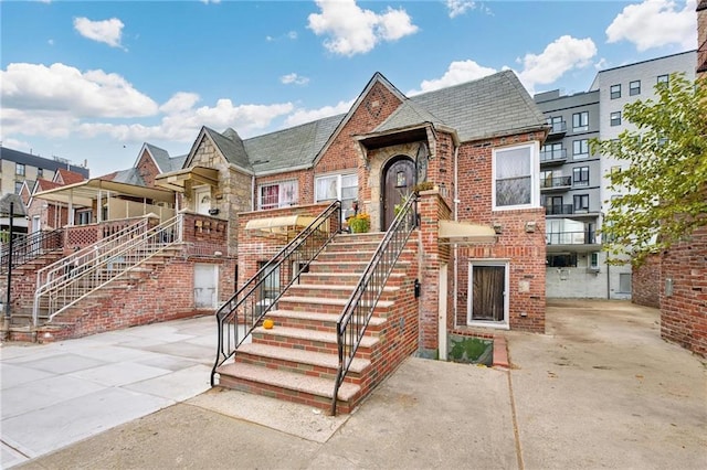 view of front facade featuring stairs and brick siding