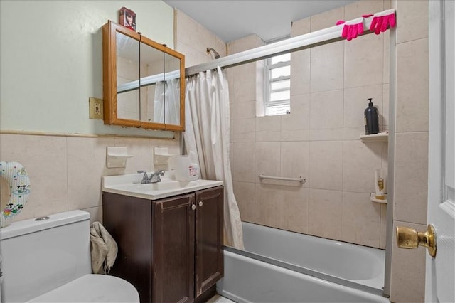 bathroom with vanity, toilet, a wainscoted wall, and shower / bath combo with shower curtain