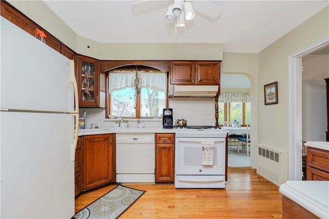249 Slosson Ave, Staten Island, NY 10314 - kitchen featuring radiator, arched walkways, white appliances, under cabinet range hood, and light wood-style floors