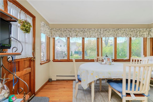 249 Slosson Ave, Staten Island, NY 10314 - dining room featuring crown molding, light wood-type flooring, a healthy amount of sunlight, and a baseboard heating unit