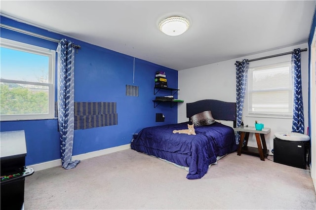 carpeted bedroom featuring baseboards and multiple windows