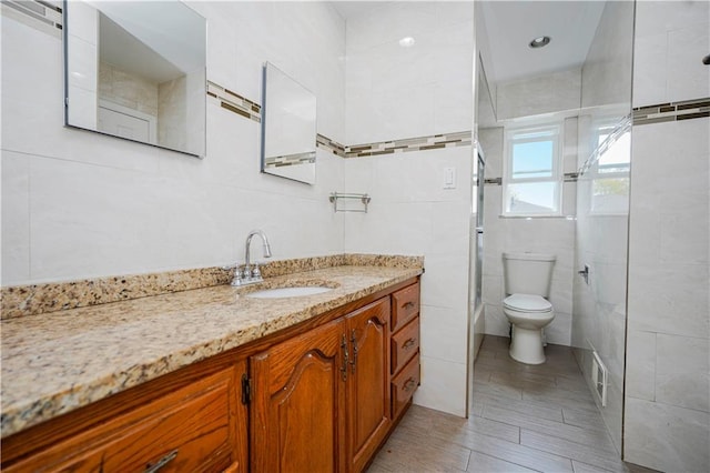 149 Forest St, Staten Island, NY 10314 - bathroom with a shower, vanity, toilet, and tile walls