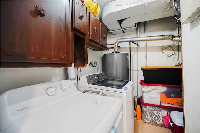 washroom featuring water heater, cabinet space, and washer and dryer