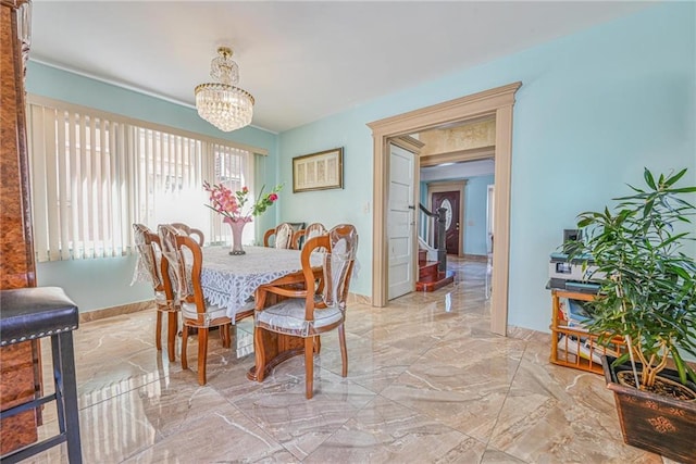 dining room with a chandelier and marble finish floor