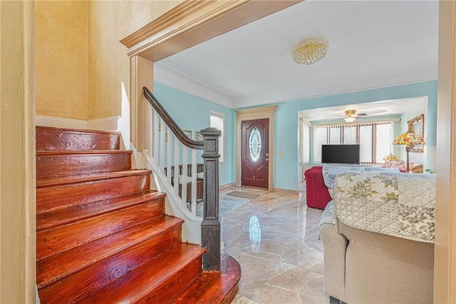 entrance foyer featuring a ceiling fan, stairs, and marble finish floor