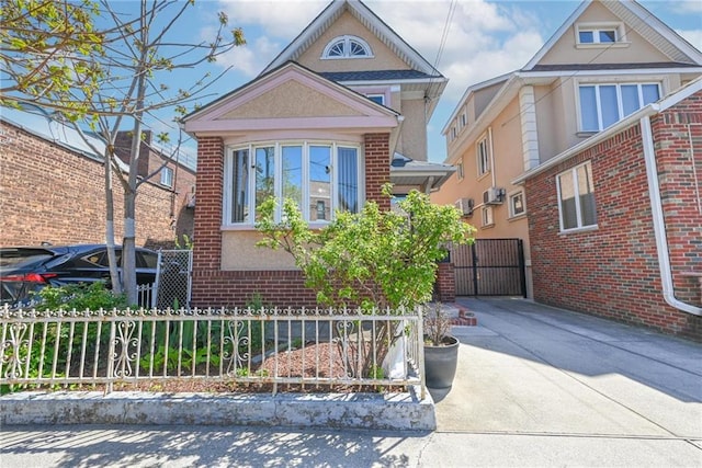 view of front of home featuring fence, a gate, and brick siding