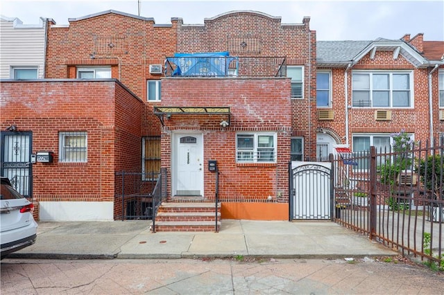 view of property with fence, a gate, and brick siding