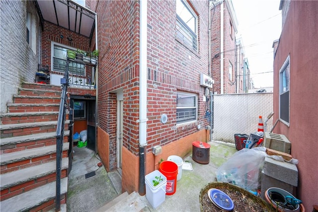 view of home's exterior with brick siding and fence