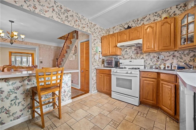 1462 E 65th St, Brooklyn, NY 11234 - kitchen featuring white range with gas cooktop, wallpapered walls, under cabinet range hood, a chandelier, and a sink
