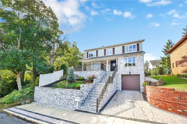 30 Beverly Rd, Staten Island, NY 10305 - traditional home with stairs, stone siding, a garage, decorative driveway, and covered porch