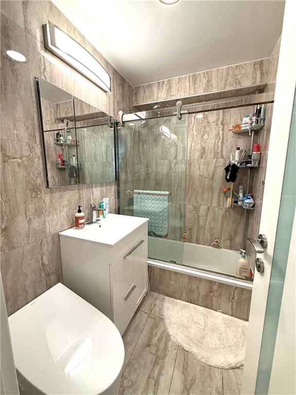 bathroom featuring vanity, tiled shower / bath combo, and tile walls
