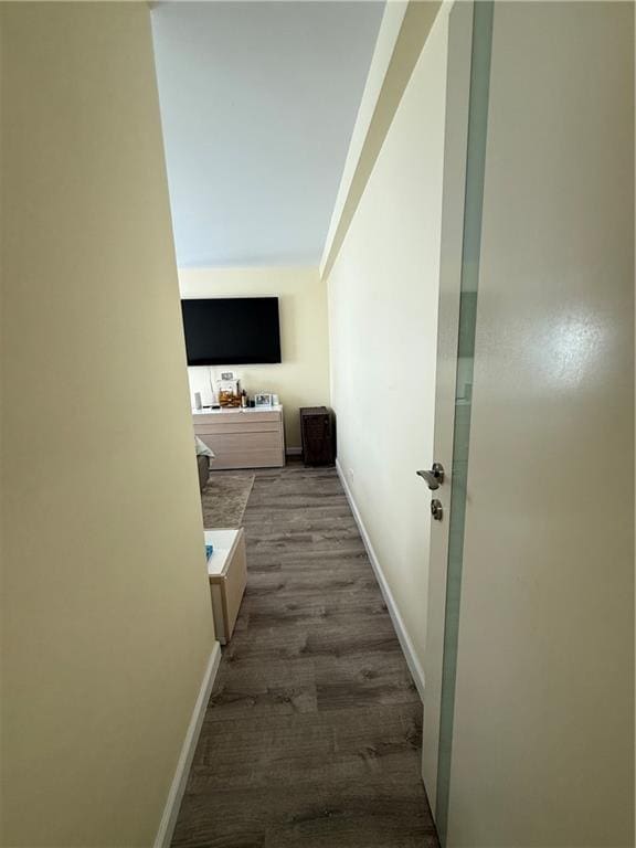 hall with baseboards and wood finished floors