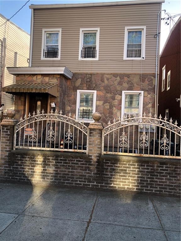 view of front of property with a gate and stone siding