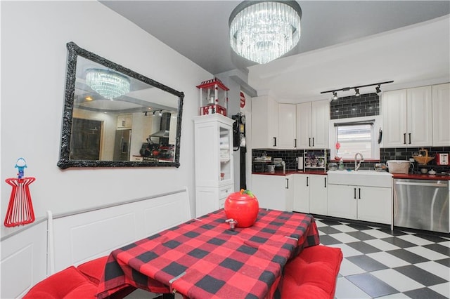 kitchen featuring a sink, a notable chandelier, white cabinets, tile patterned floors, and appliances with stainless steel finishes