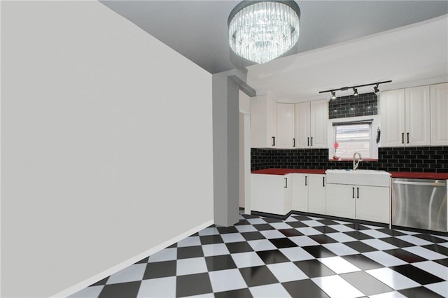 kitchen with stainless steel dishwasher, a sink, white cabinetry, backsplash, and dark floors