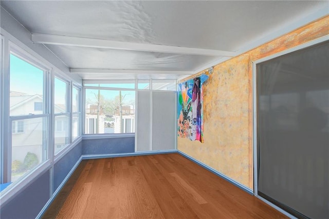 unfurnished sunroom with wood finished floors and beamed ceiling