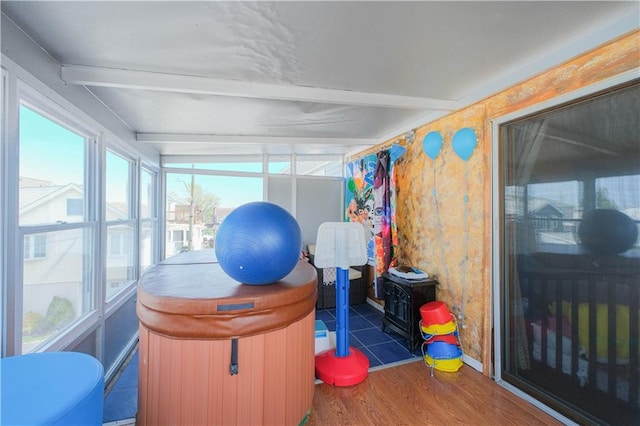 sunroom with wood finished floors and beam ceiling