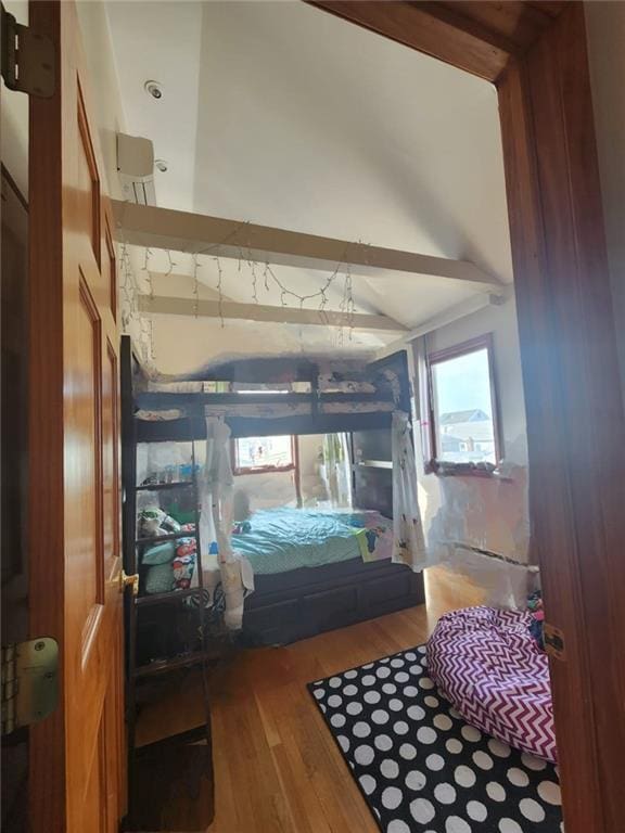 bedroom with lofted ceiling and wood finished floors