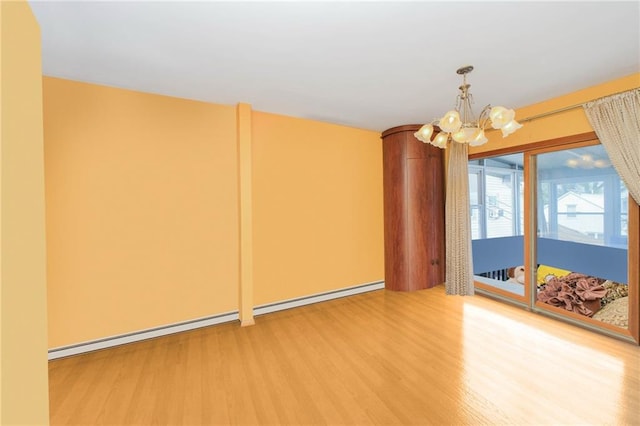empty room with baseboard heating, a chandelier, and wood finished floors