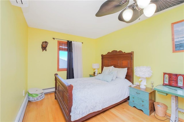 bedroom featuring a ceiling fan, a baseboard radiator, and light wood-style floors