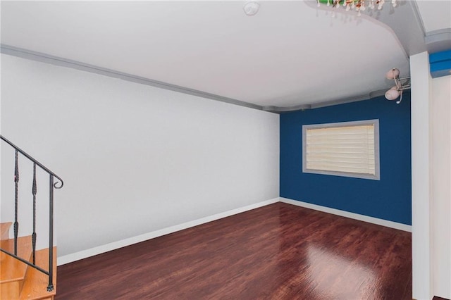 spare room featuring stairway, baseboards, and wood finished floors