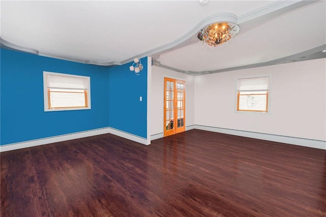 empty room with baseboards, plenty of natural light, and wood finished floors