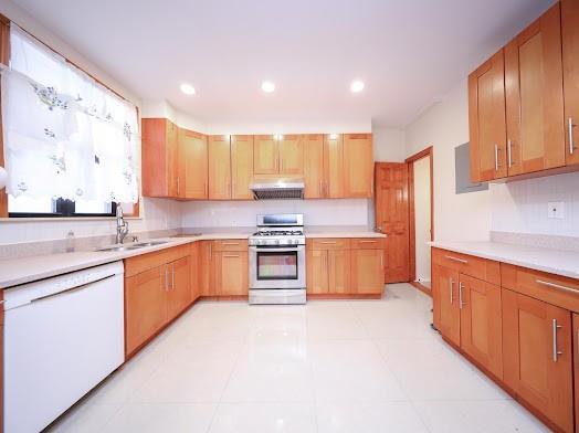 299 Bay 13th St, Brooklyn, NY 11214 - kitchen with stainless steel gas stove, under cabinet range hood, white dishwasher, a sink, and light countertops